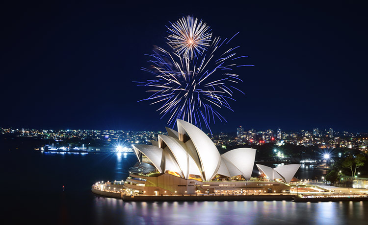 Fireworks exploding in the night sky over the Sydney Opera House.
