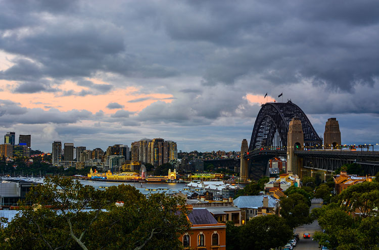 Sydney Harbour Bridge and waterfront with warm evening colors.