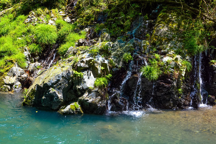 Cool spring cascading over rocks into the Kiyotaki River.