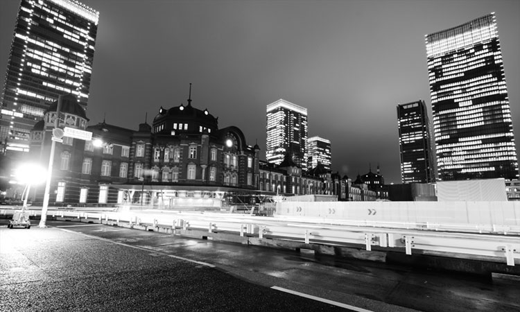 Black and white of the Marunouchi side of Tokyo Station at night.