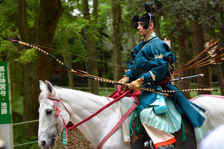 Archer wielding a traditional Japanese bow at the Yabusame Shinji event in Kyoto.